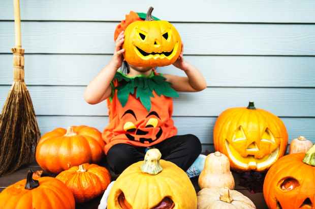 child holding jack o lantern